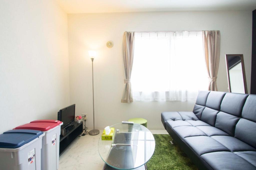 uma sala de estar com um sofá e uma mesa de vidro em Sannand / Vacation STAY 2187 em Sapporo