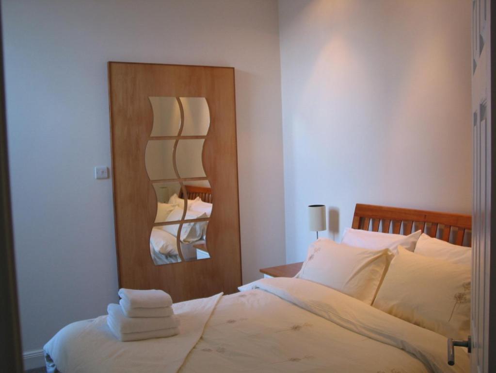 a bedroom with a large bed and a mirror at Waverley Place in Kirkton of Largo