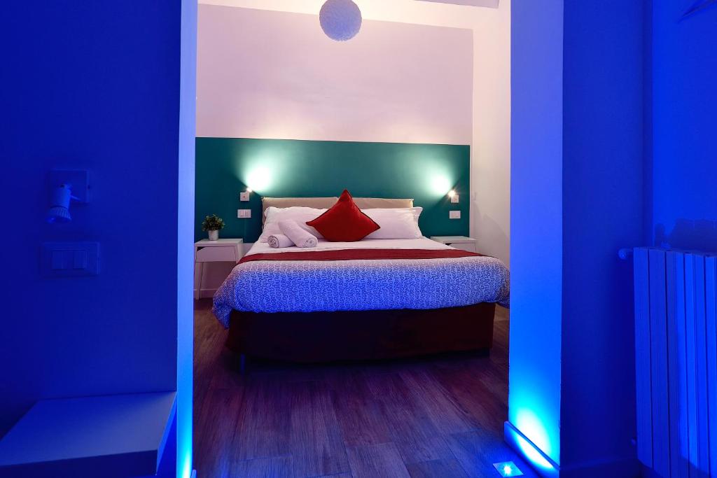 una camera da letto con un grande letto con cuscini rossi di Modica Old Town Rooms - Self check-in a Modica
