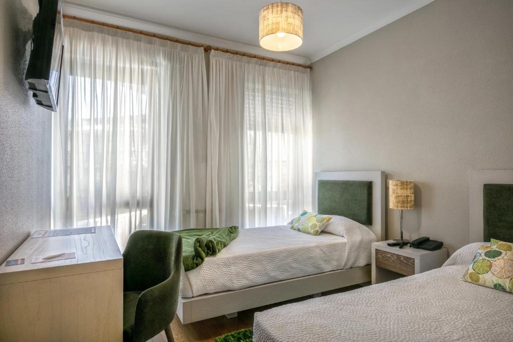 a bedroom with two beds and a window at Classico in Vila Real