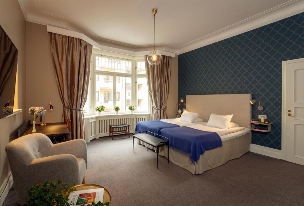 um quarto de hotel com uma cama e uma cadeira em Pärlan Hotell em Estocolmo