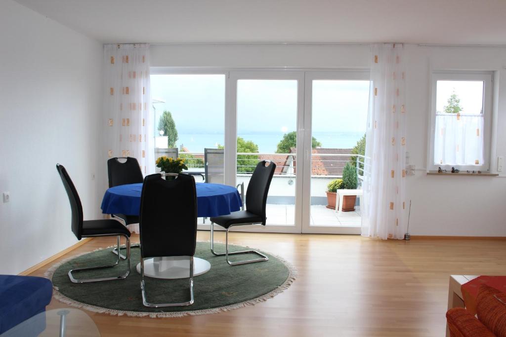a dining room with a blue table and black chairs at Mühlgarten in Immenstaad am Bodensee