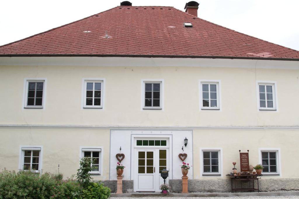 uma casa branca com um telhado vermelho em Gutshof Bartl 1 em Klagenfurt