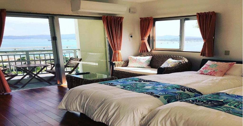two beds in a room with a view of the ocean at 220 Kouri Nakijin-son - Hotel / Vacation STAY 8715 in Nakijin