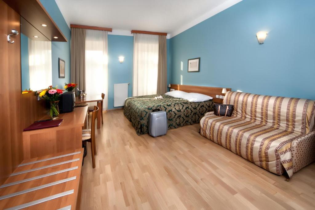 ein Hotelzimmer mit einem Bett und einem Sofa in der Unterkunft Hotel Residence Select in Prag