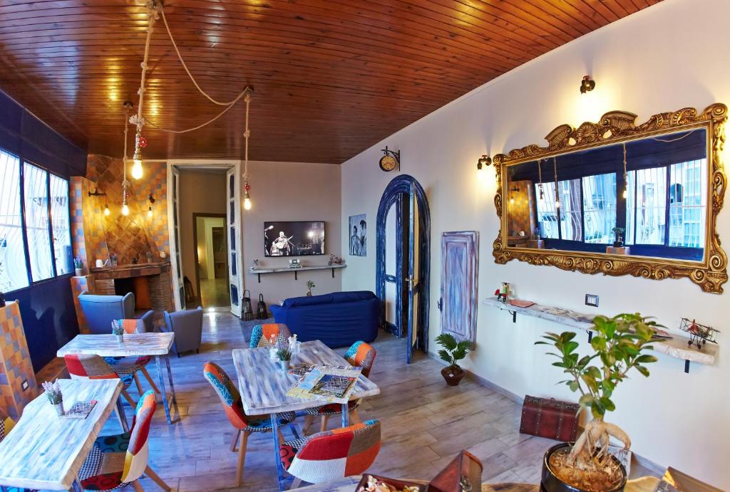 a restaurant with tables and chairs and a mirror at Artisti Sustinea Rooms in Naples