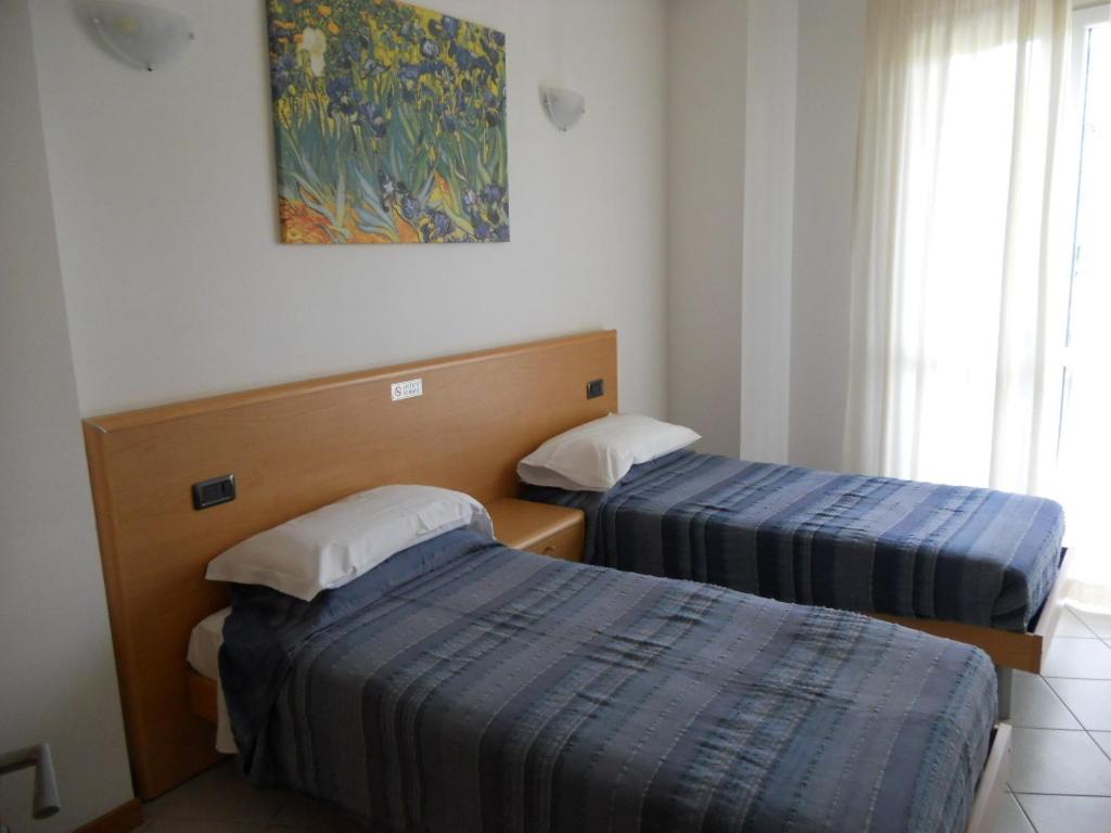 ein Hotelzimmer mit 2 Betten und einem Gemälde an der Wand in der Unterkunft Residence Dulcis In Fundo in Urgnano