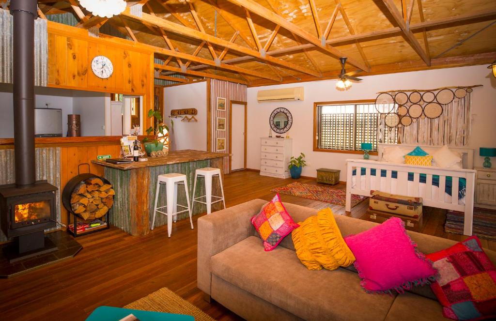 a living room with a couch and a stove at Peppercorn Cabin in Broke