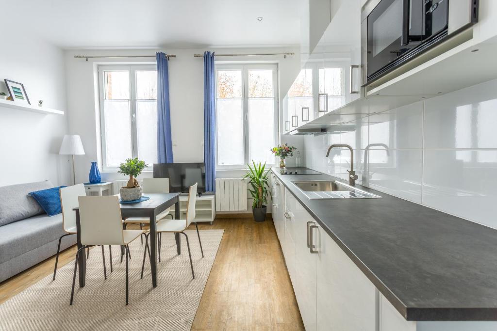 a kitchen and living room with a table and chairs at Appartement Vacances Picardie in Amiens