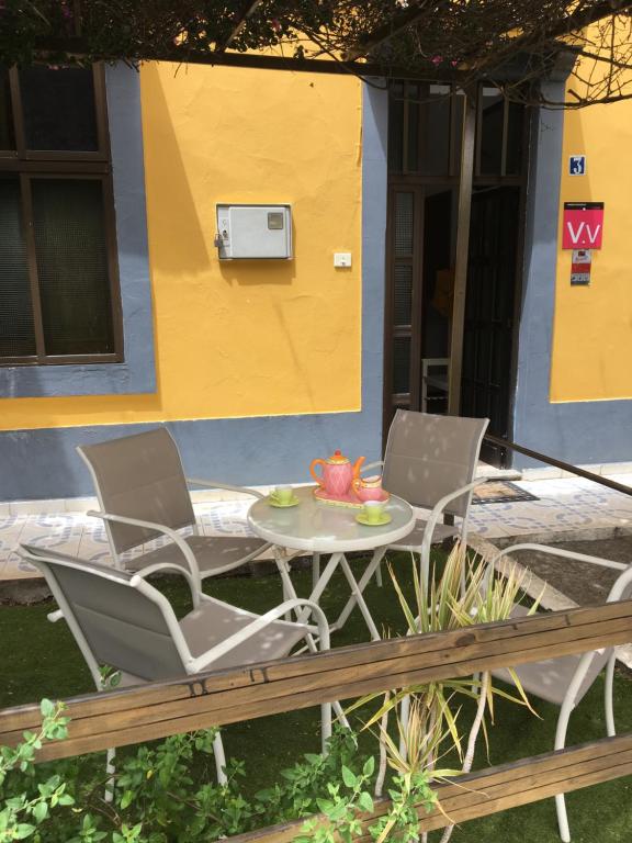 two chairs and a table in front of a house at Casa Norb in Teror