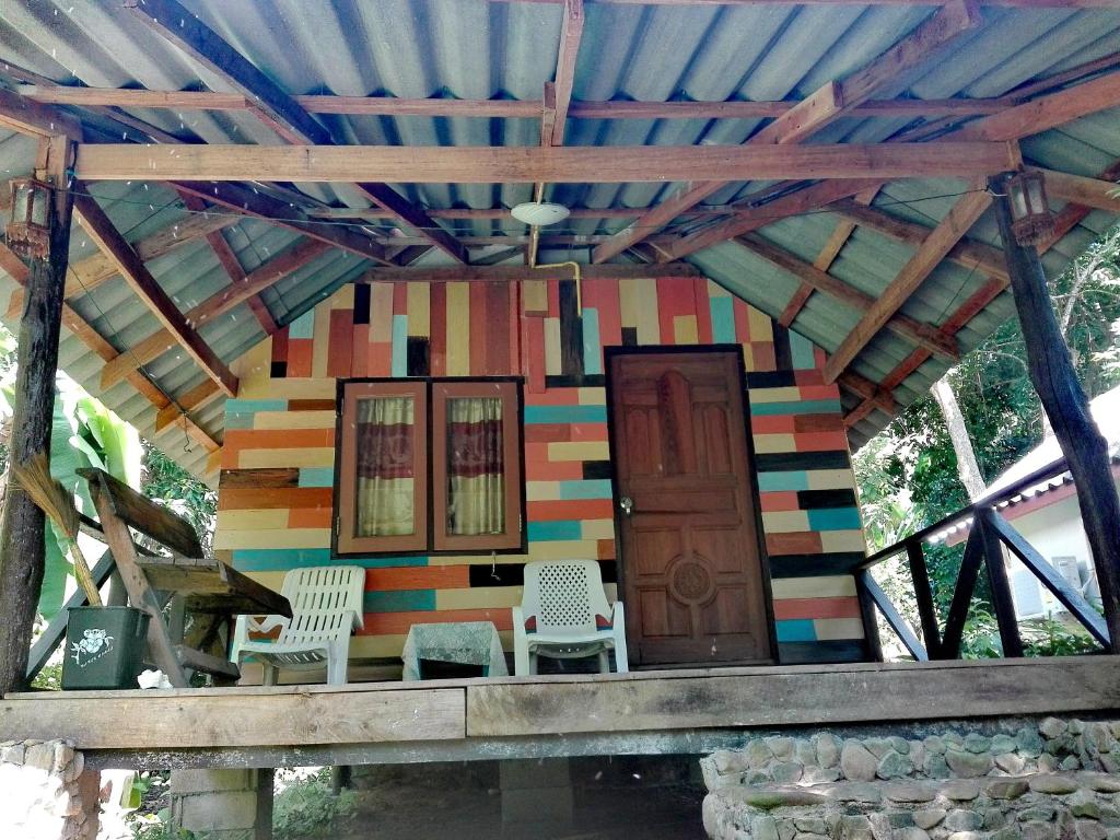 een kleurrijk huis met twee stoelen en een deur bij Mayow Bungalow Kohmook Trang in Trang