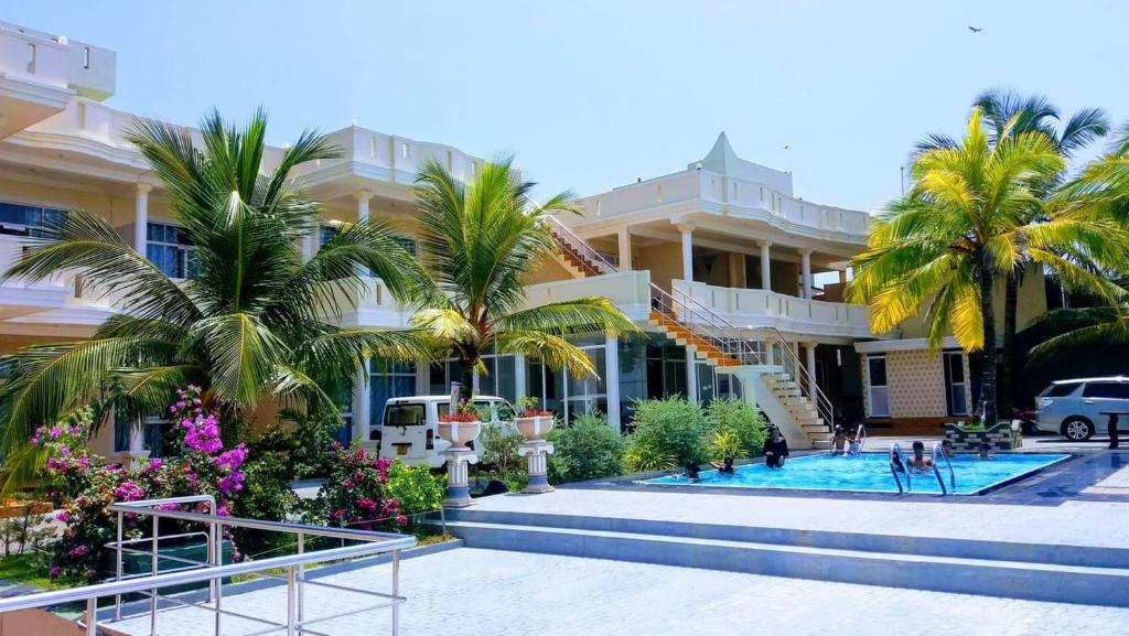 ein großes Gebäude mit Palmen und einem Pool in der Unterkunft Bochum Lanka Resort in Beruwala