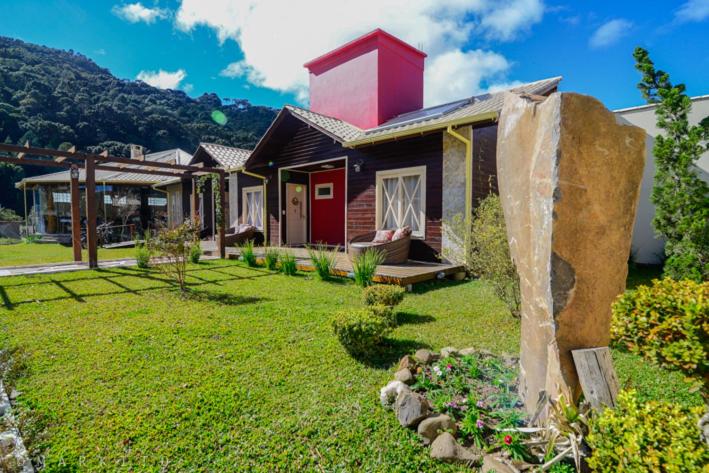 a house with a red tower on top of a yard at Pousada Requinte Serrano in Urubici