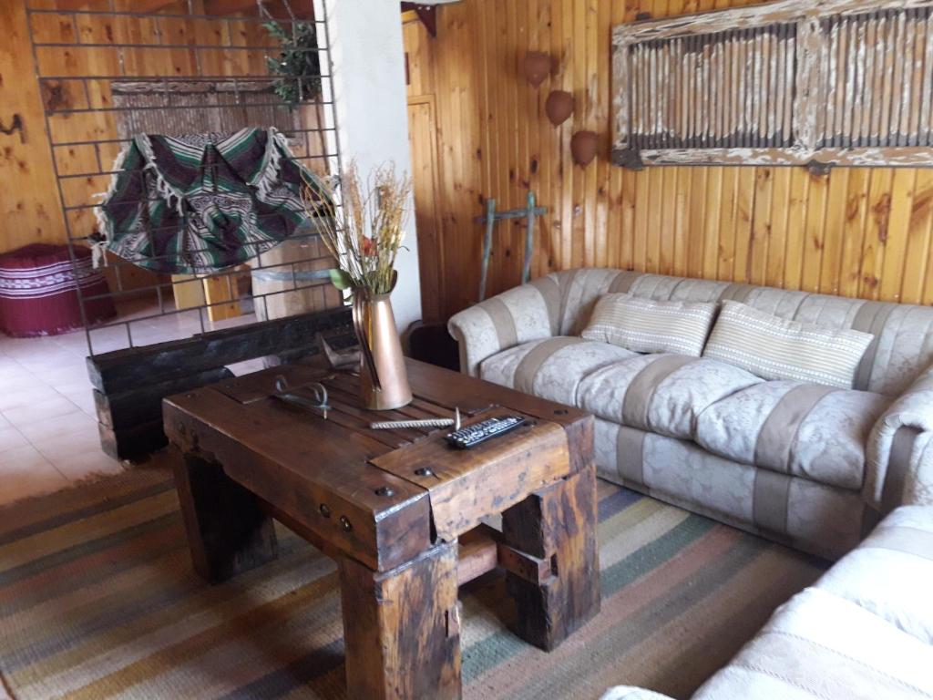 ein Wohnzimmer mit einem Sofa und einem Couchtisch in der Unterkunft Hostal Arce Marrón in Limache