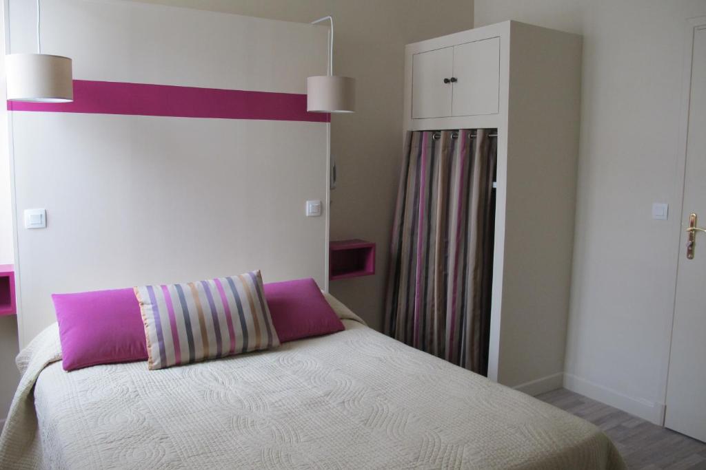 a bedroom with a bed with a purple headboard at Hotel Le Havre Bleu in Beaulieu-sur-Mer