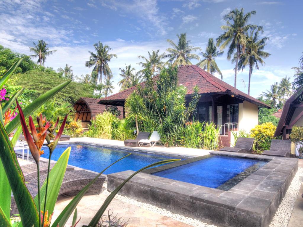 a swimming pool in front of a house at Gili Air Bungalows in Gili Air