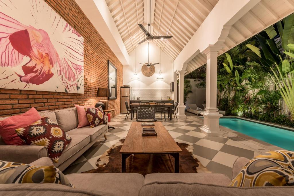 a living room with a couch and a table at Villa Kilau in Seminyak