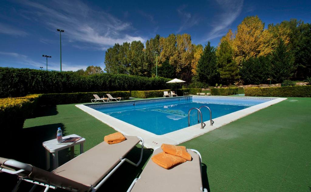 una piscina en un patio con sillas alrededor en Parador de Teruel en Teruel