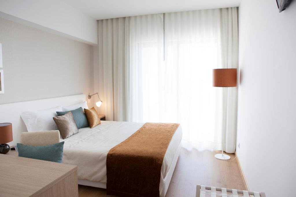 a hotel room with a bed and a window at Lam Hotel Villa Aljustrel in Aljustrel