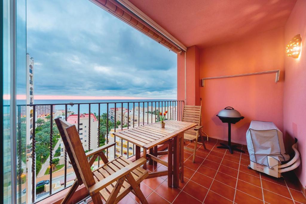 a balcony with a table and chairs and a large window at Apartamento Torrevieja Sunrise Atalayas in Torrevieja
