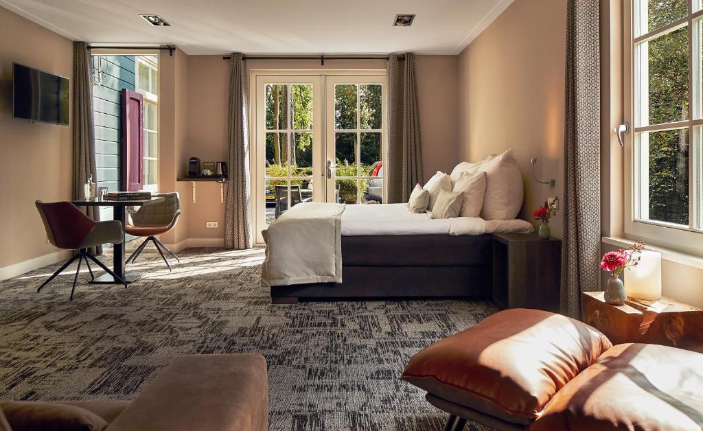 1 dormitorio con cama, mesa y sofá en Fort Resort Beemster, en Zuidoostbeemster