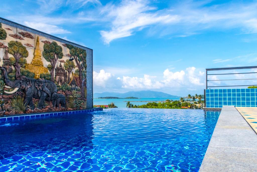 a swimming pool with a mural on the side of a building at Celebrity Ocean View Villa Samui in Bangrak Beach