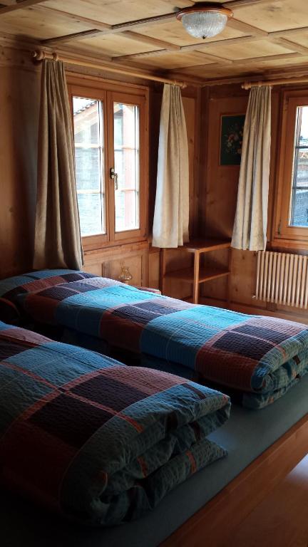 2 łóżka w drewnianym pokoju z oknami w obiekcie Apartment Astrid w mieście Münster