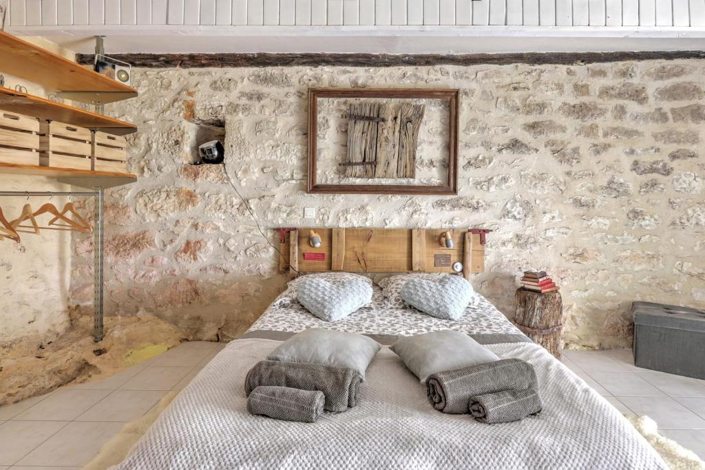 um quarto com uma cama grande numa parede de pedra em Le Mas Des Papillons chambre d'hôtes B&B em Fargues