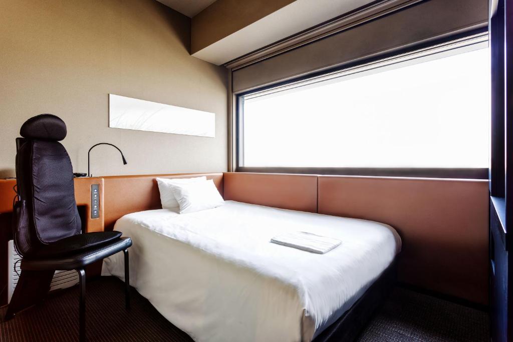 Postel nebo postele na pokoji v ubytování remm Shin-Osaka
