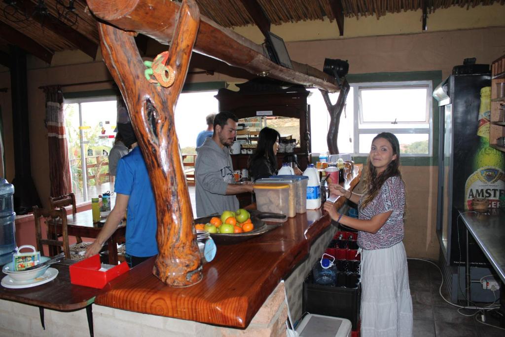 a group of people standing at a counter in a restaurant at The Wild Farm Backpackers in Wilderness