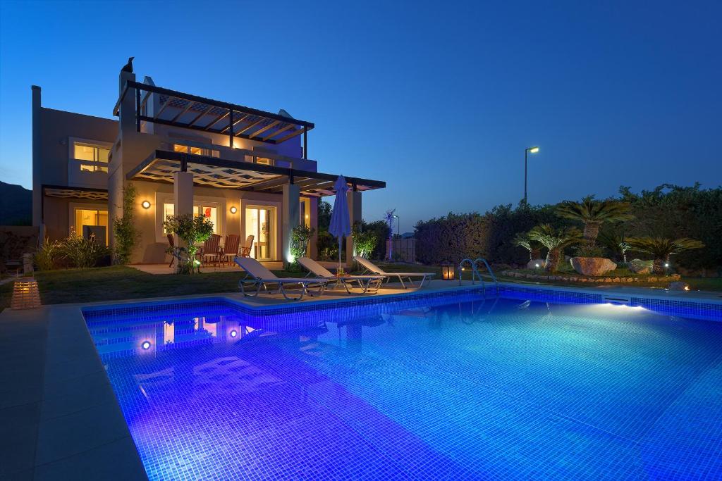 ファリラキにあるEvergreen Seaside Villa with private poolの夜間のスイミングプール付きハウス
