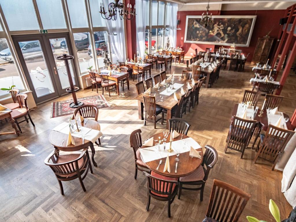 einen Blick über ein Restaurant mit Tischen und Stühlen in der Unterkunft Hotel Gutenberger in Lübeck
