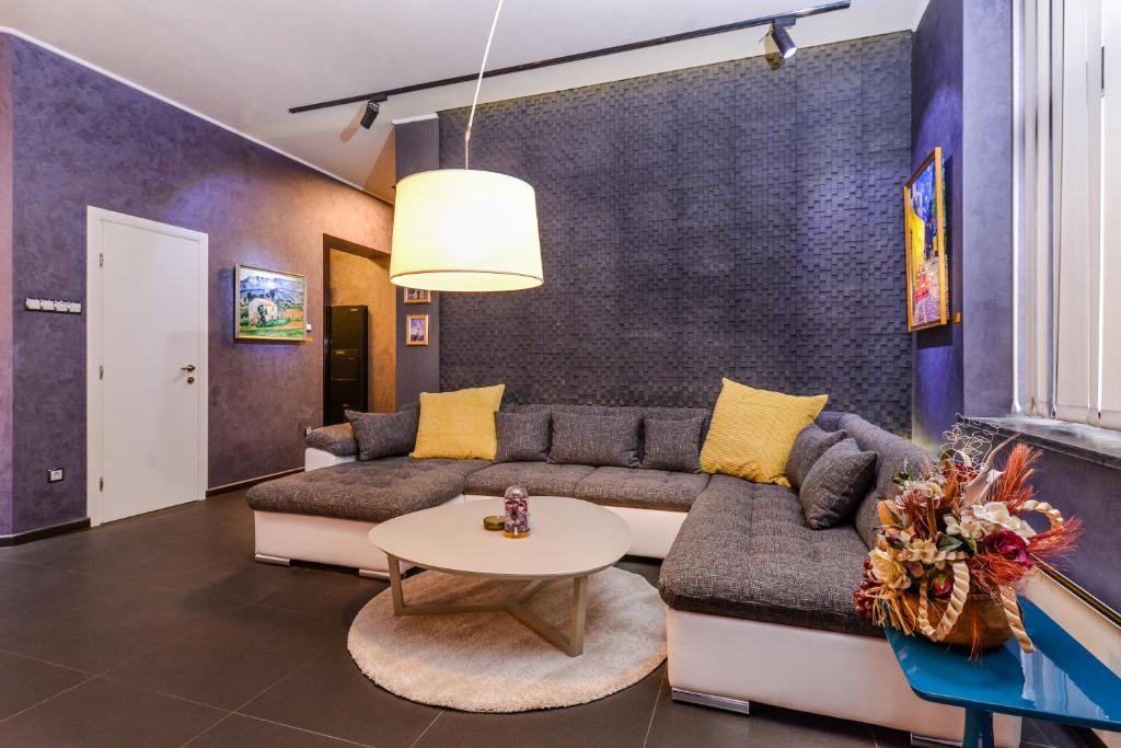 ein Wohnzimmer mit einem Sofa und einem Tisch in der Unterkunft Champs-Élysées Sofia | 2-BDR, 2-BTHR Tsar Simeon Suite in Sofia