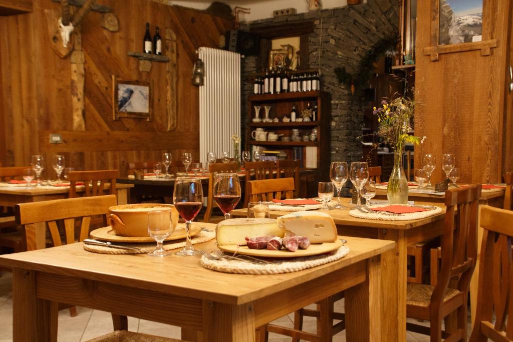 a dining room with wooden tables and chairs with wine glasses at Baita Layet in Breuil-Cervinia
