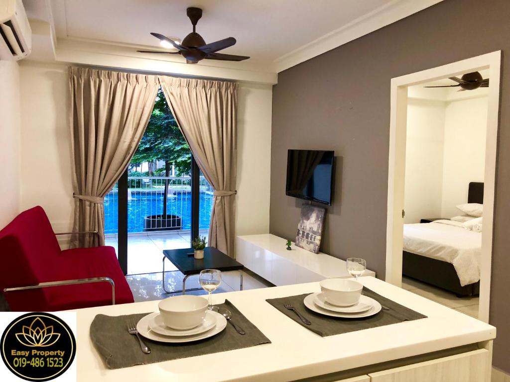 a living room with a table and a room with a bed at Solstice Cyberjaya by Easy Property in Cyberjaya