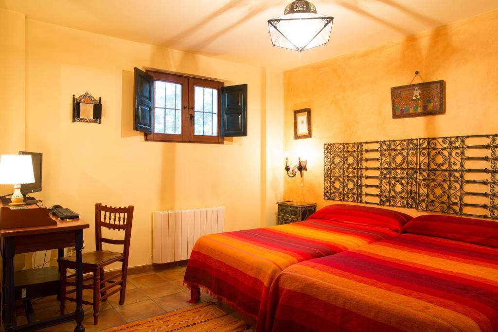 um quarto com uma cama, uma mesa e uma secretária em Cortijo El Canjilón MONTEFRÍO em Montefrío