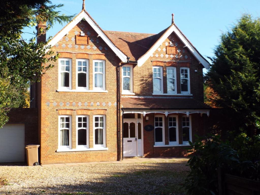 a large brick house with a white door at Brookside Lodge in Baldock
