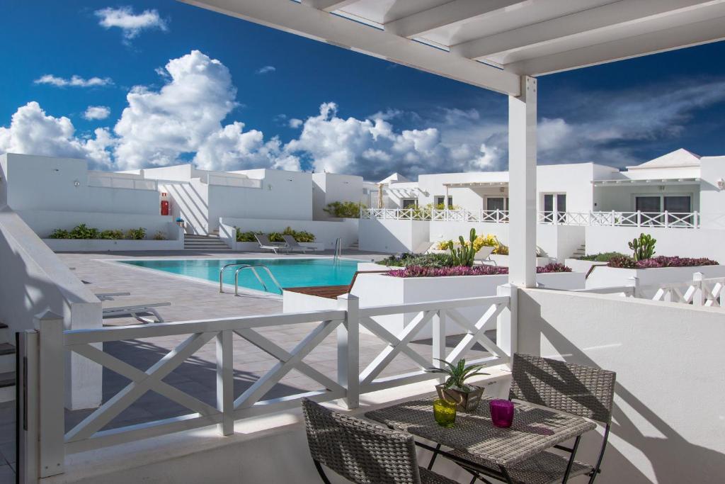 vistas a la piscina desde el balcón de una villa en Flower Beach Suite 16 en Playa Honda