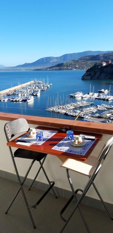 una mesa con 2 sillas y un puerto deportivo con barcos en B&B Il Convento, en Agropoli