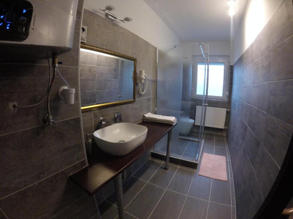 a bathroom with a sink and a shower at Dózsaház in Zalaegerszeg