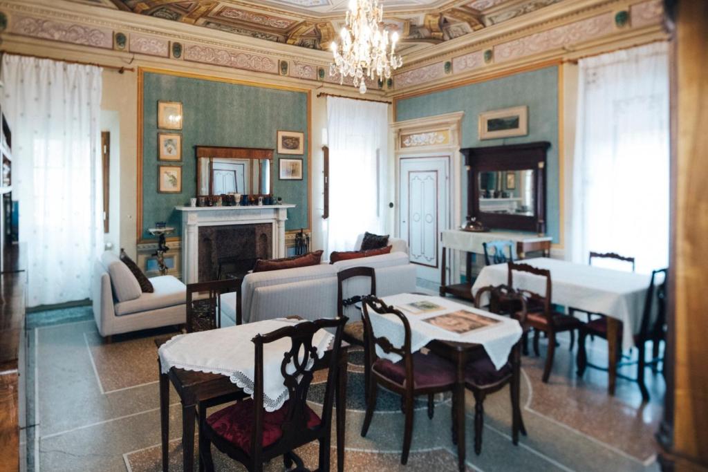 salon ze stołami i krzesłami oraz żyrandolem w obiekcie Villa Moris bed and breakfast w mieście Tavarnelle Val di Pesa