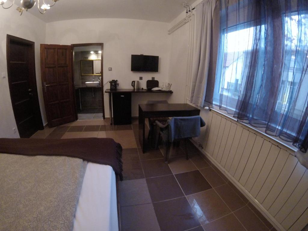 a room with a bed and a desk and a window at Dózsaház in Zalaegerszeg