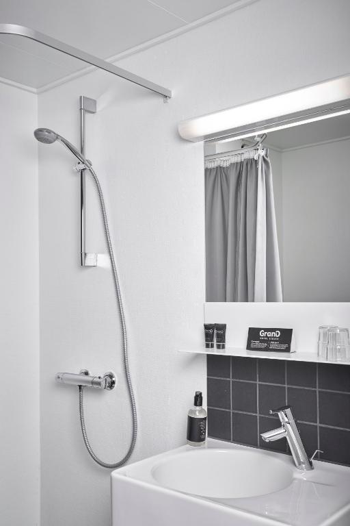 un bagno bianco con lavandino e doccia di Struer Grand Hotel a Struer