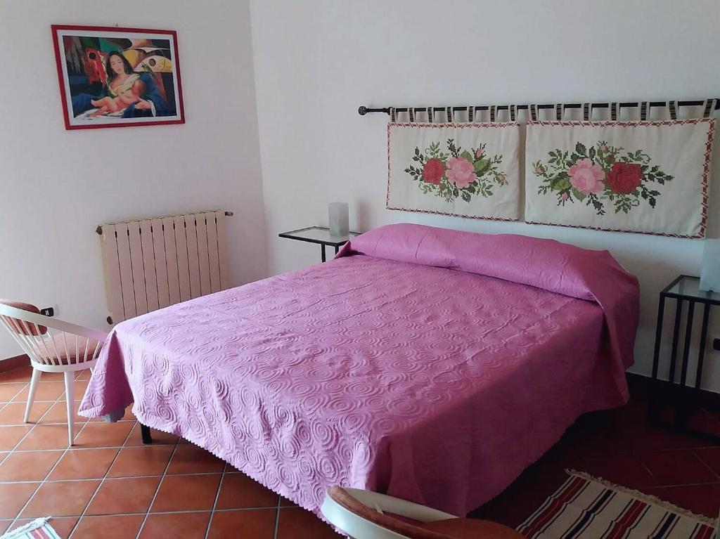 1 dormitorio con cama rosa y edredón rosado en Miscalè House, en Cattolica Eraclea