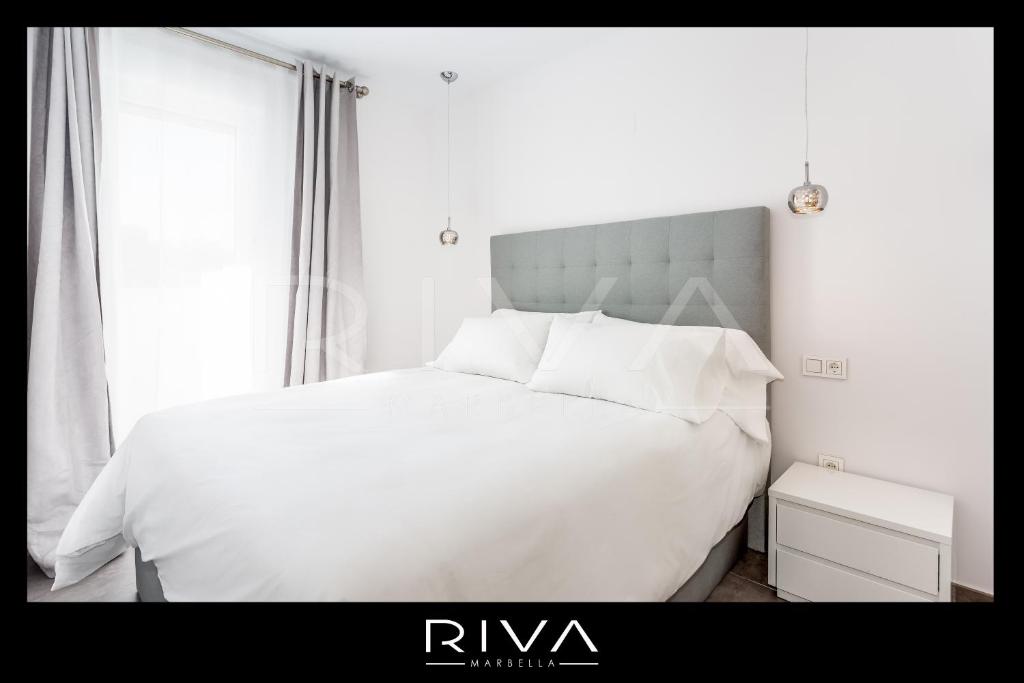 białe łóżko z białą pościelą i poduszkami w sypialni w obiekcie by Riva - 4 bedroom apartment in Dama de noche w Marbelli