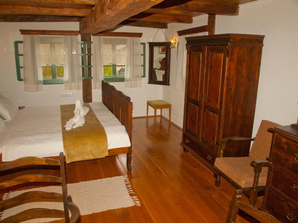 a bedroom with a bed and a cabinet and a chair at Stara Iža in Selišće Sunjsko