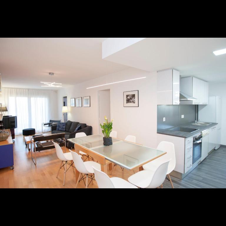 a kitchen and living room with a table and chairs at Pis del Mercat -aire acondicionado en todas las habitaciones y salón- in Deltebre