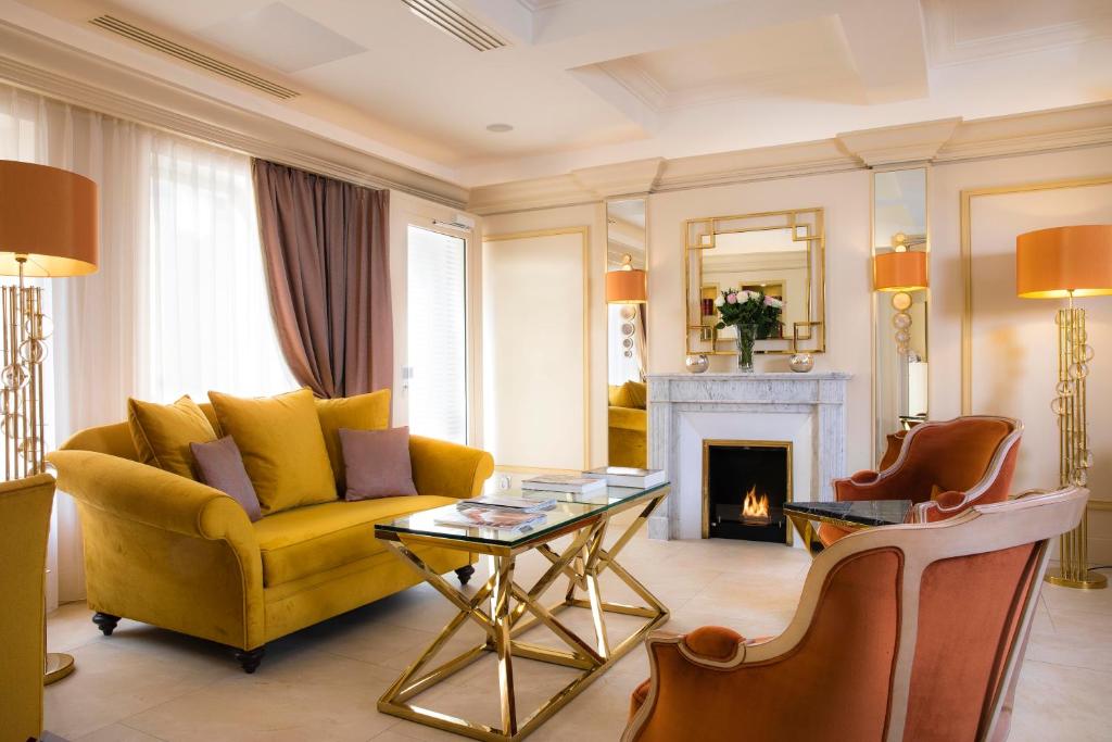 - un salon avec un canapé jaune et une cheminée dans l'établissement Hotel De Suede Saint Germain, à Paris