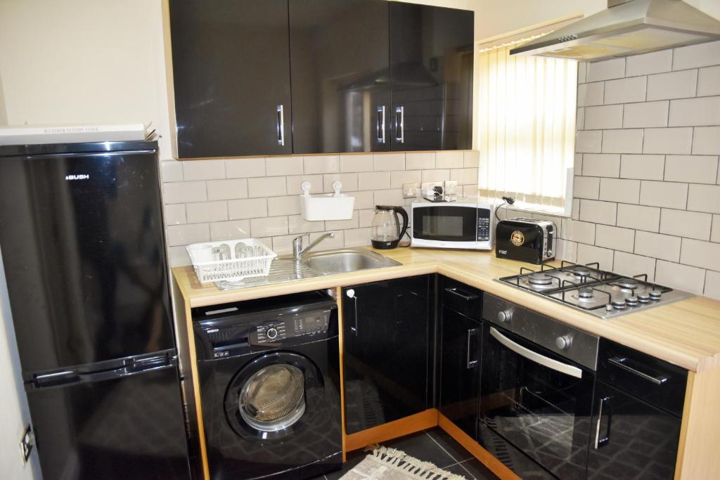 a kitchen with a sink and a stove and a dishwasher at Luxury Duplex Apartment in Bedford