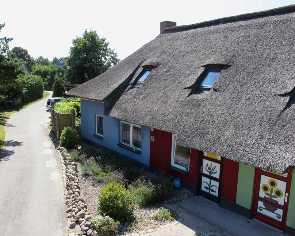 ein Haus mit einem Strohdach und einer Straße in der Unterkunft K01 Fischerkaten Haus HELENA max 5 Personen in Dorf Körkwitz